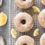 Lemon baked donuts with lemon glaze on a wire rack.