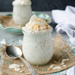Coconut overnight oats in jars with coconut flakes on top.