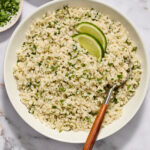 Cilantro lime cauliflower rice in a bowl with serving spoon.