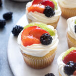 Fruit tart vanilla cupcakes on a serving board.