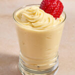 Pastry cream piped into a glass with strawberry on top.