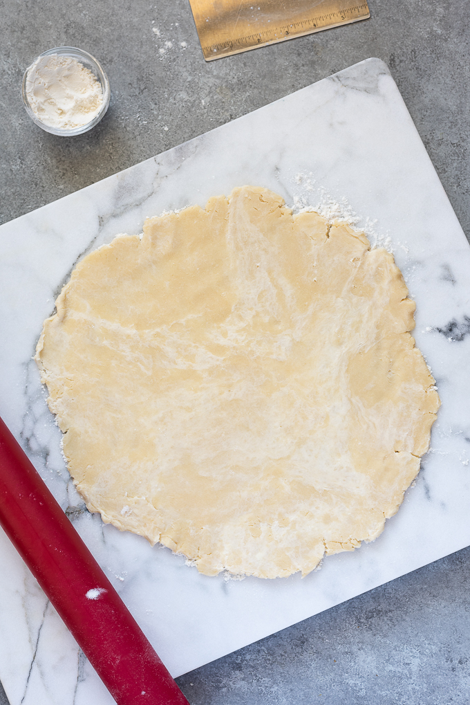 Galette dough rolled out onto marble board.