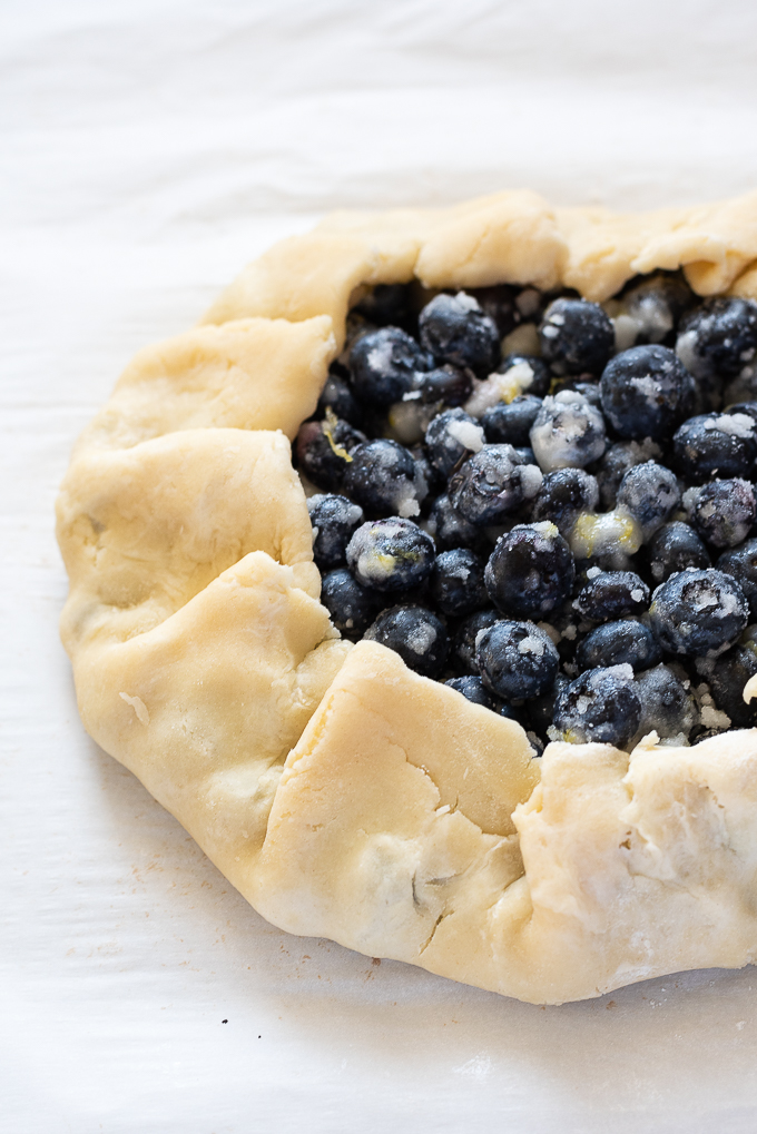 Edges crimped around blueberry galette.