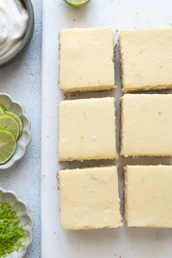 Cooled cheesecake bars cut into squares.