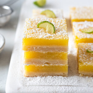 Key lime shortbread bars stacked on top of each other.