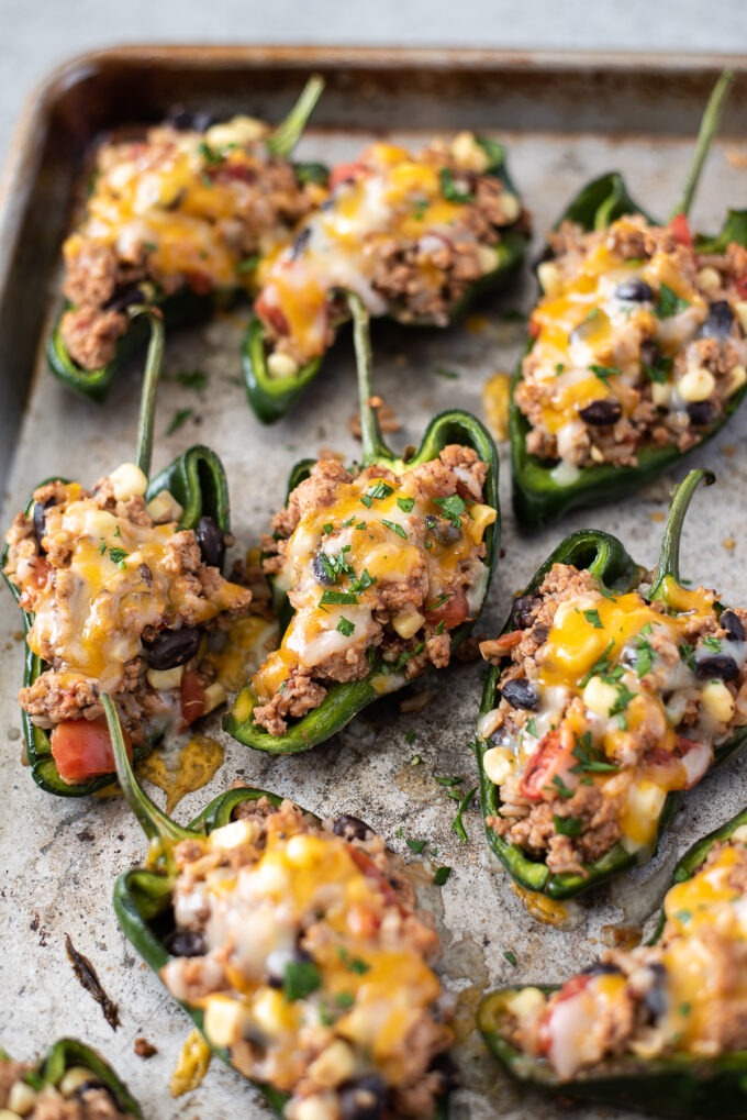 Stuffed poblano peppers with ground turkey on baking sheet.