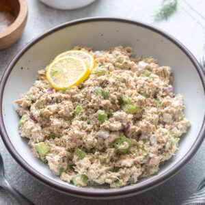 Canned salmon salad in a serving bowl with lemon.