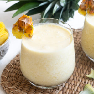 Easy pina colada in high ball glass with pineapple garnish.