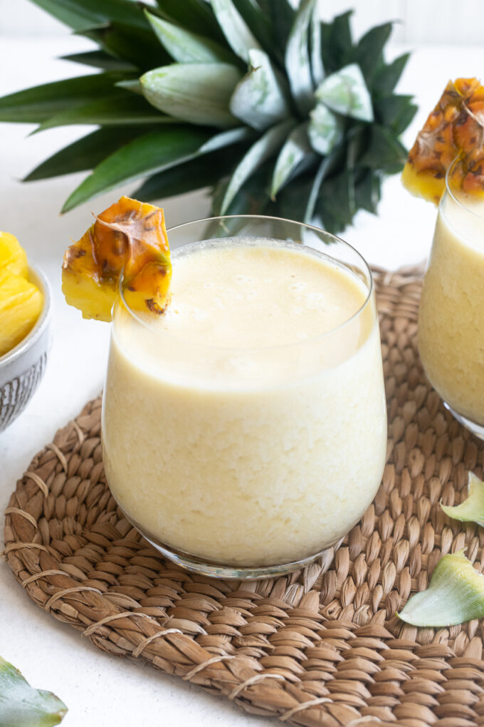 Easy pina colada in high ball glass with pineapple garnish.