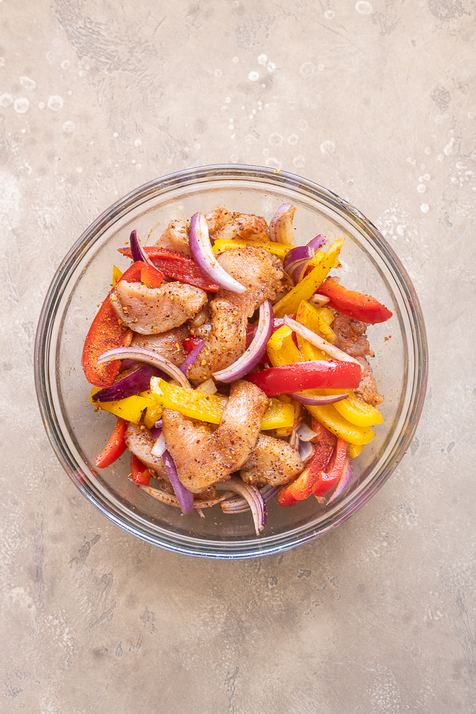 Toss the fajita chicken and vegetables with oil and seasoning.