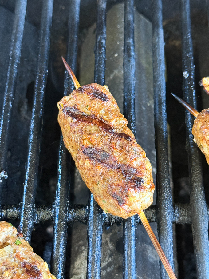 Grilled lamb kofta on the grill on second side.