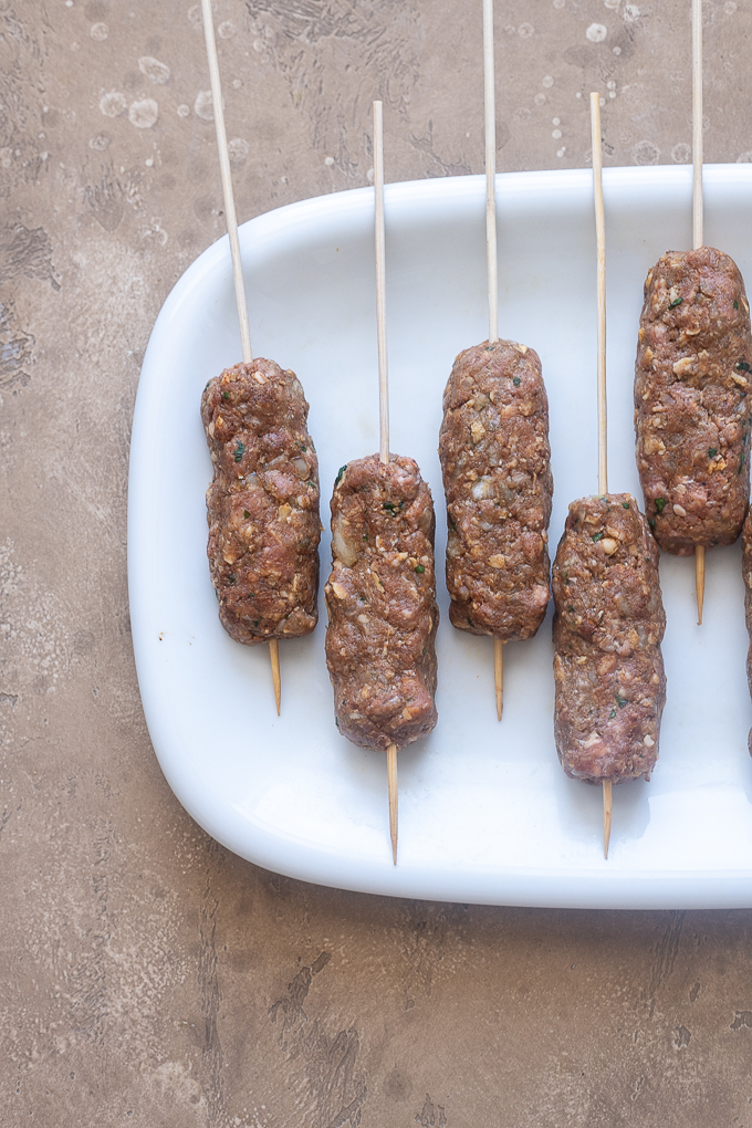 Lamb kofta formed into oblong logs and skewered.