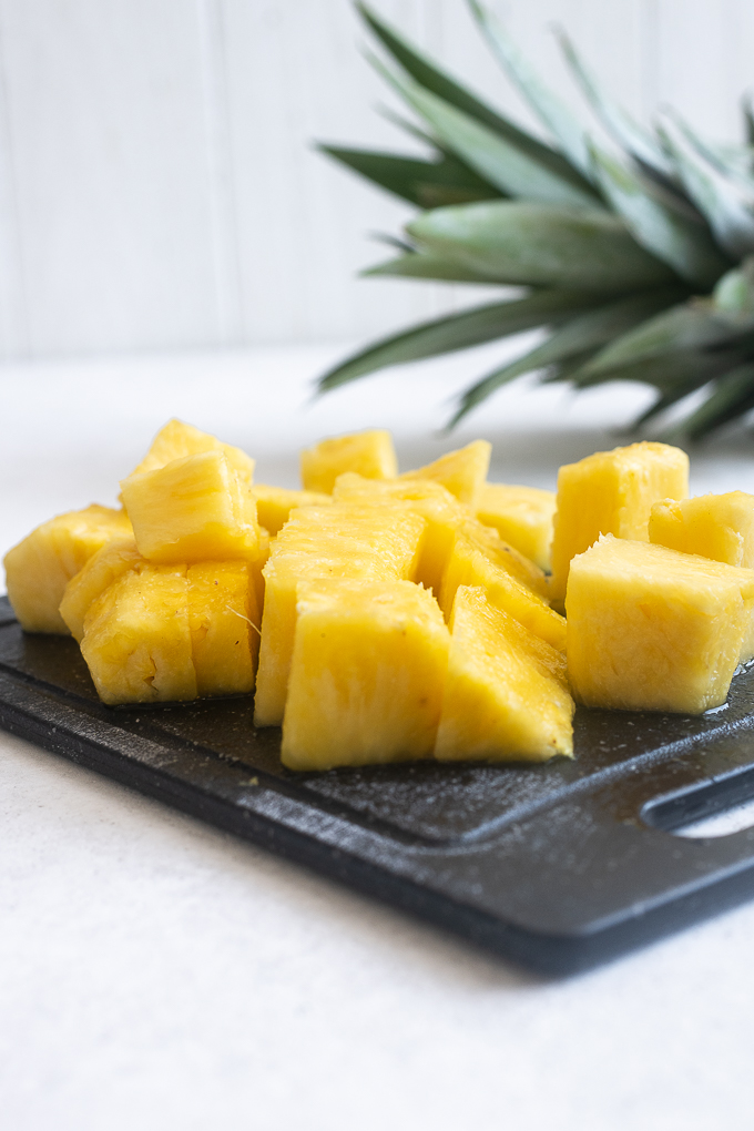 Fresh pineapple chunks on a cutting board.