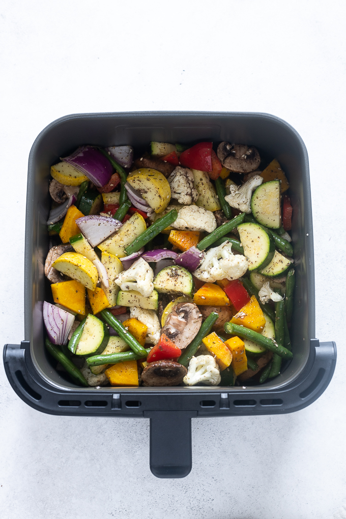Vegetables in air fryer before cooking.