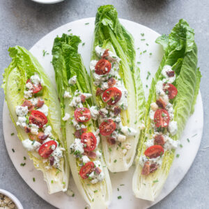Romaine wedge salad with bacon and blue cheese on a platter.