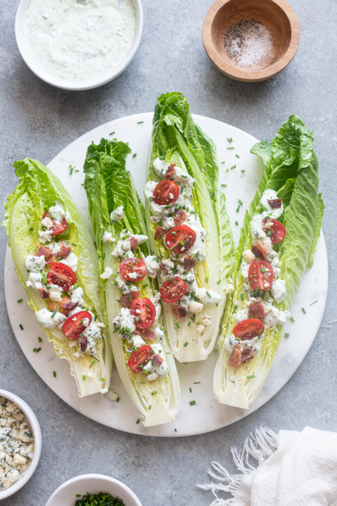 Romaine wedge salad with bacon and blue cheese on a platter.