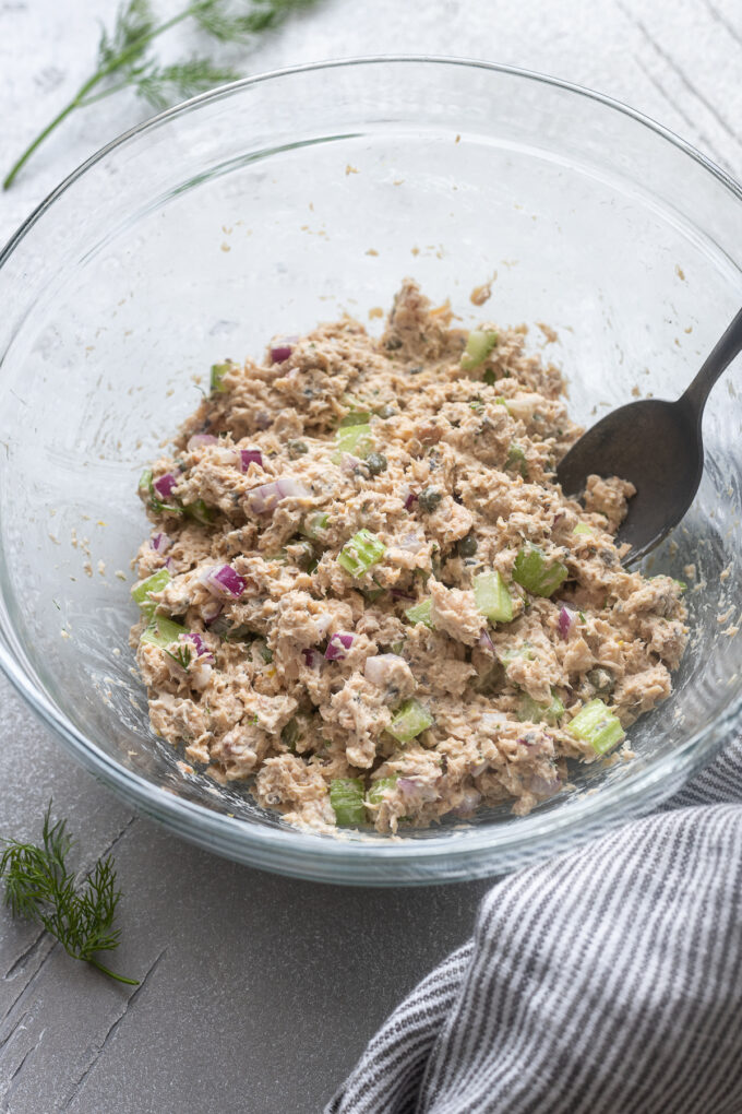 Salmon salad in a mixing bowl with a spoon.