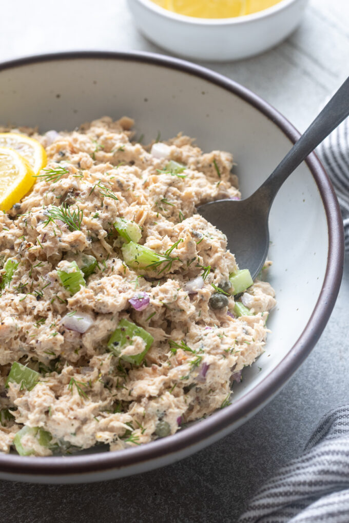 Serving spoon digging into canned wild salmon salad.