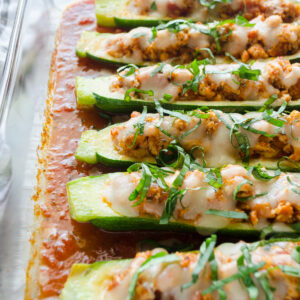 Chicken parmesan stuffed zucchini boats in a baking dish.