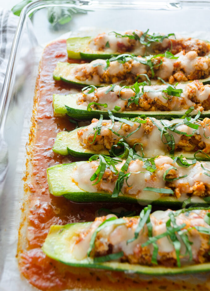 Chicken parmesan stuffed zucchini boats in a baking dish.