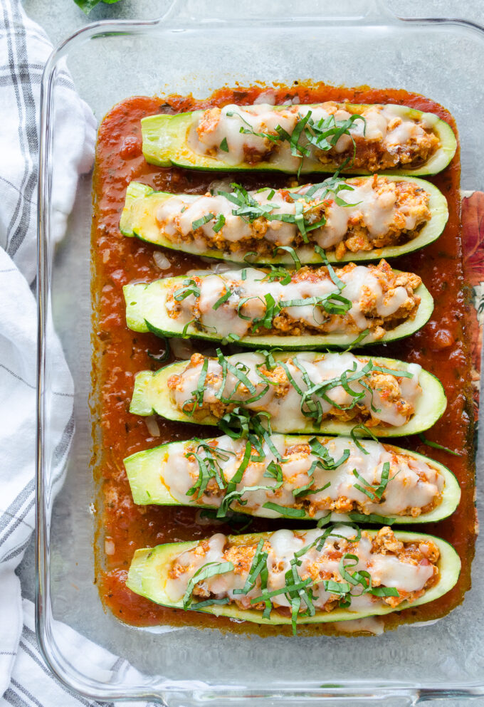 Chicken parmesan stuffed zucchini in a baking dish.