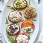 Heirloom tomato flight on a white platter with basil.