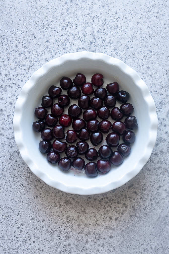 Place pitted cherries in a greased 9" baking dish.