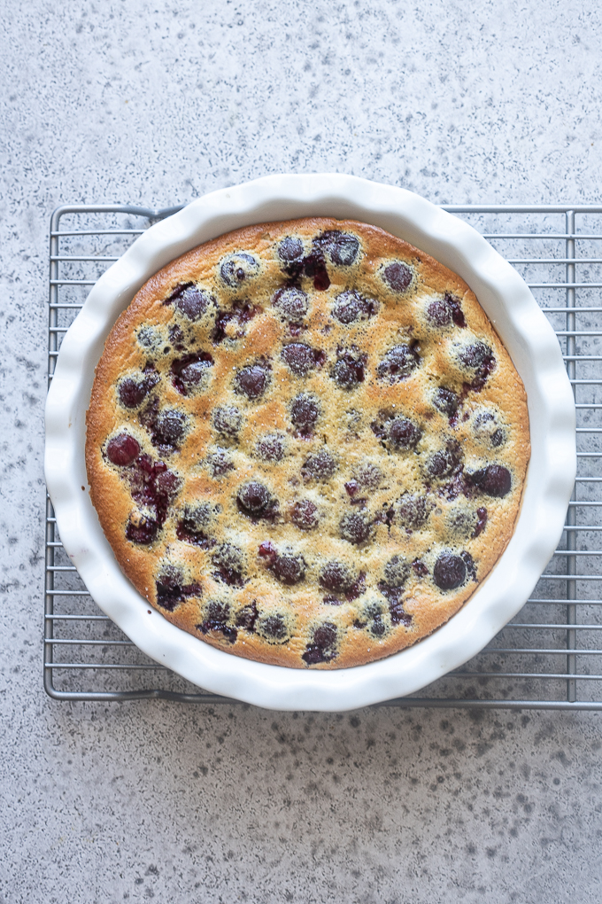 Baked cherry clafoutis on a wire rack.