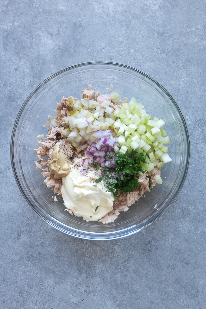 Tuna salad with pickle ingredients in a mixing bowl.