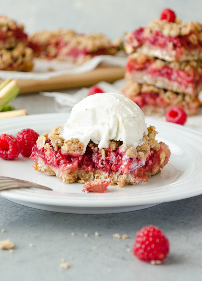 Raspberry rhubarb crumble bars with ice cream on top.