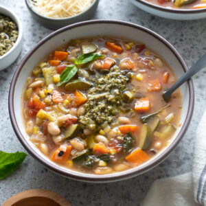 Summer vegetable soup with pesto in a bowl.