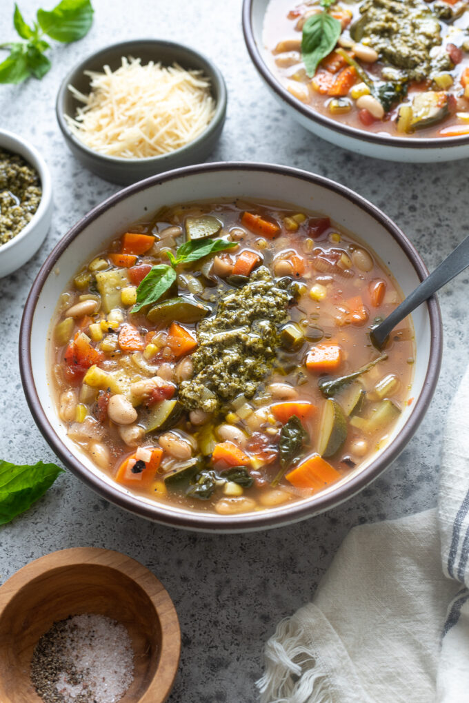 Summer vegetable soup with pesto in a bowl.