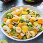 Tropical fruit salad with coconut in a serving bowl.