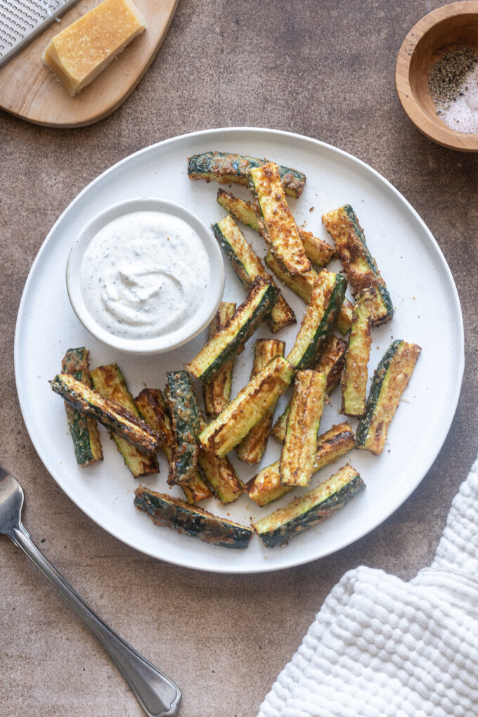 Air fryer zucchini fries on a plate with Greek yogurt ranch dip.
