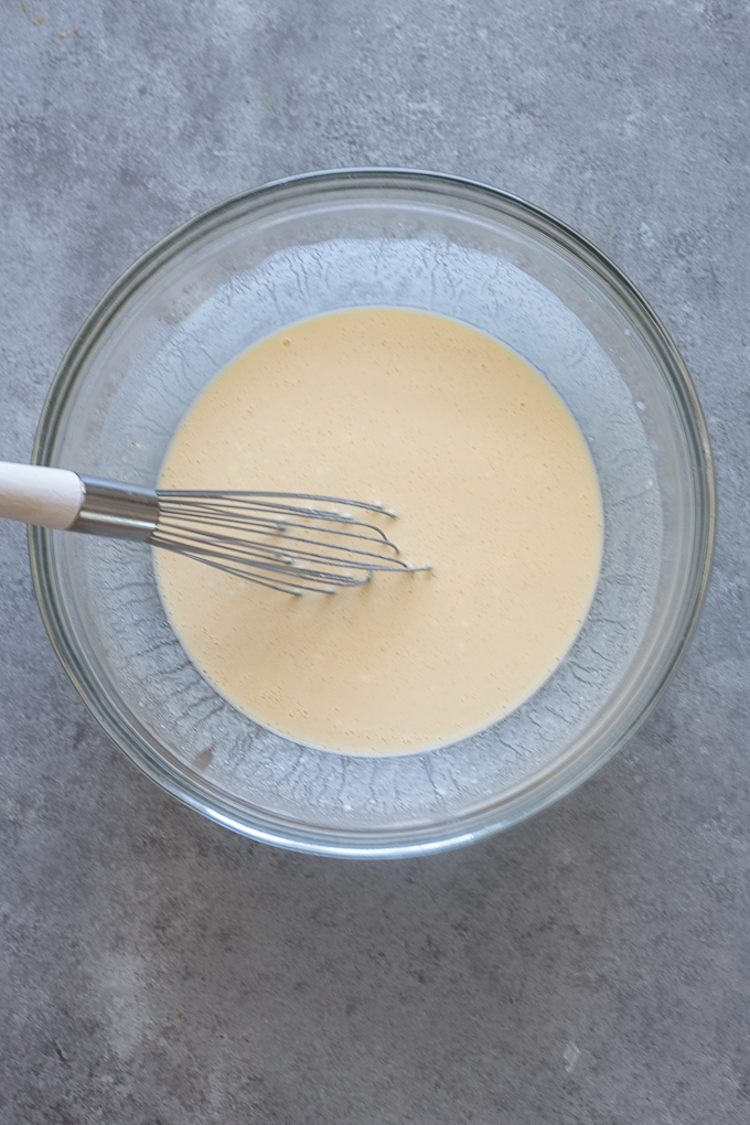 Wet ingredients in mixing bowl for oat flour Greek yogurt pancakes.
