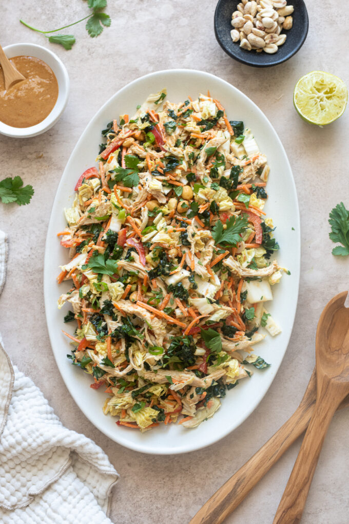 Thai peanut chicken salad on a platter with peanut dressing.