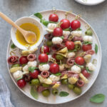 Antipasto skewers on a platter with Italian dressing.