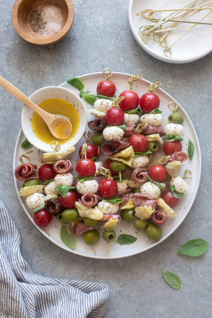 Antipasto skewers on a platter with Italian dressing.