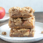 Stack of apple pie bars on a plate.