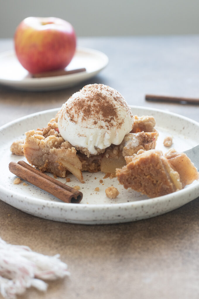 Apple Pie Bars with shortbread crust and crumb topping on white plate.