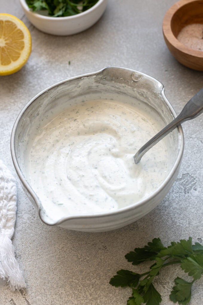 Greek yogurt ranch dressing in a bowl with a spoon.