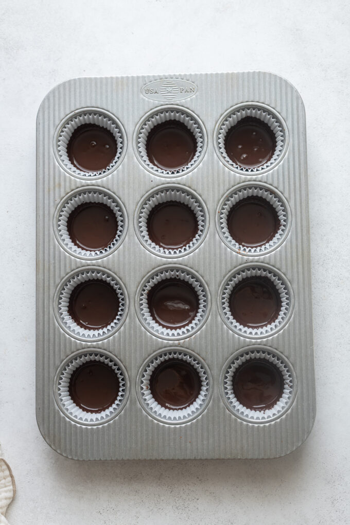 Melted dark chocolate in bottom of paper liners for peanut butter cups.