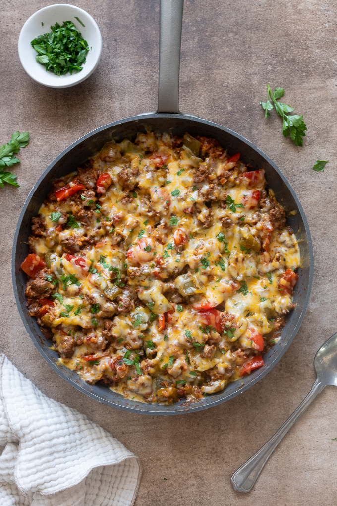 Stuffed pepper casserole topped with melted cheese and parsley.