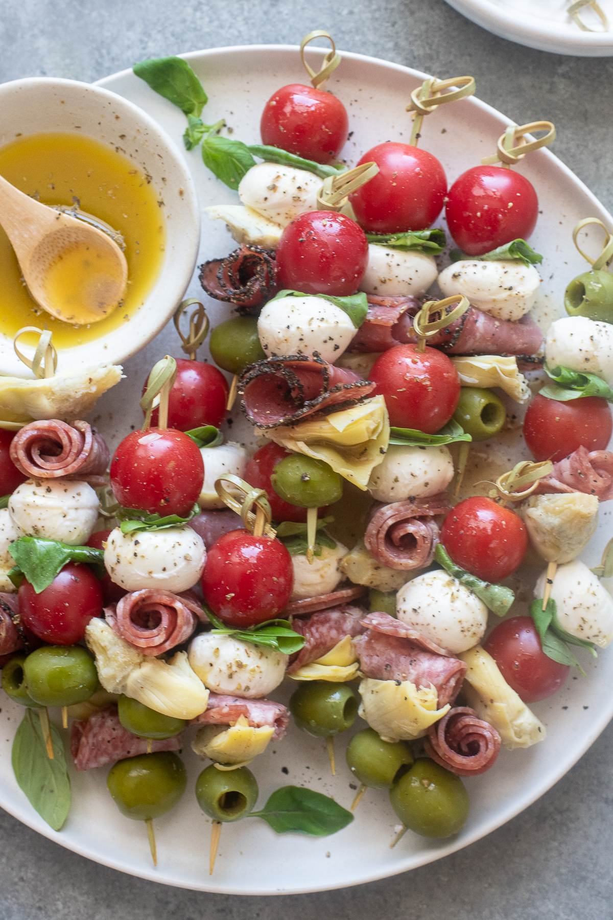 Mini Italian antipasto skewers drizzled with Italian dressing.
