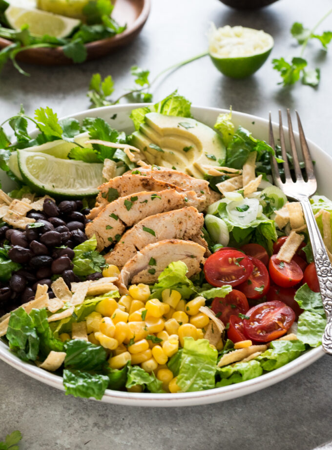 Santa fe chicken salad on a white plate with lime wedge.