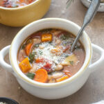 Bowl of Autumn Vegetable Soup topped with parmesan cheese.