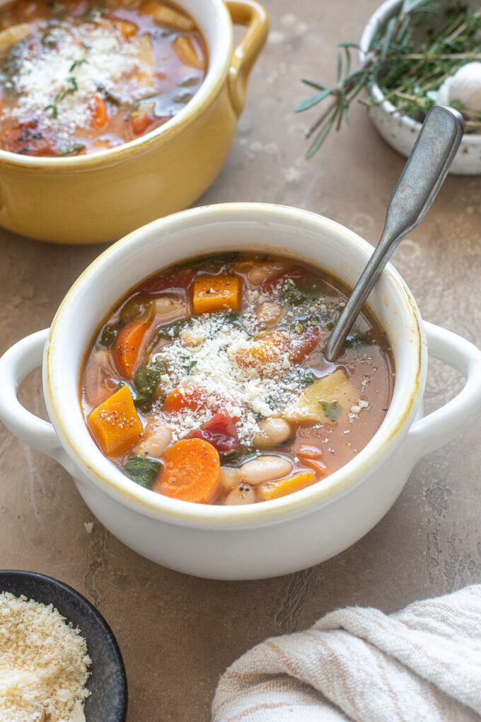Bowl of Autumn Vegetable Soup topped with parmesan cheese.