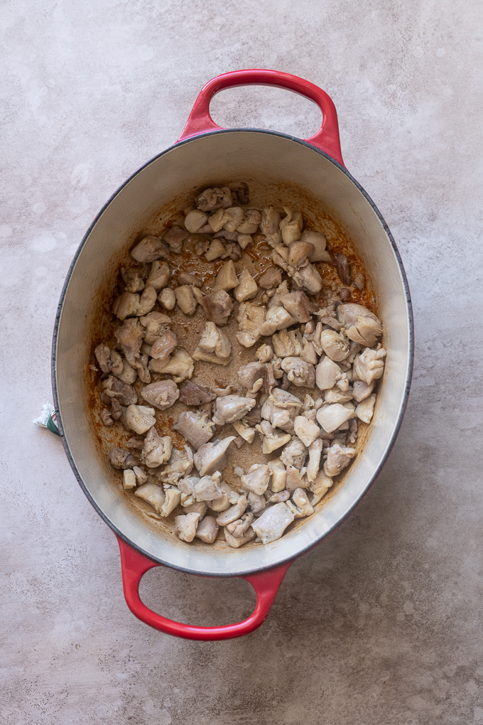Browned chicken thighs in Dutch oven for Moroccan chicken soup.