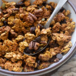 Spoonful of pumpkin spice protein granola in a bowl.