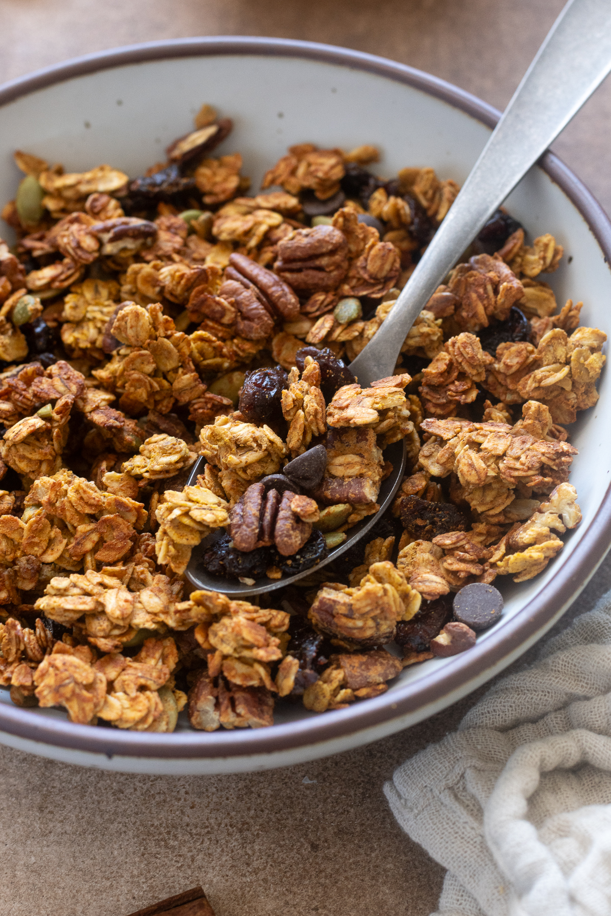 Spoonful of pumpkin spice protein granola in a bowl.